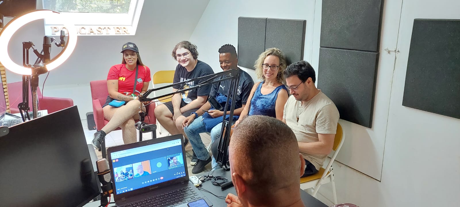 Aula presencial de podcast com ring light e turma em roda no estúdio