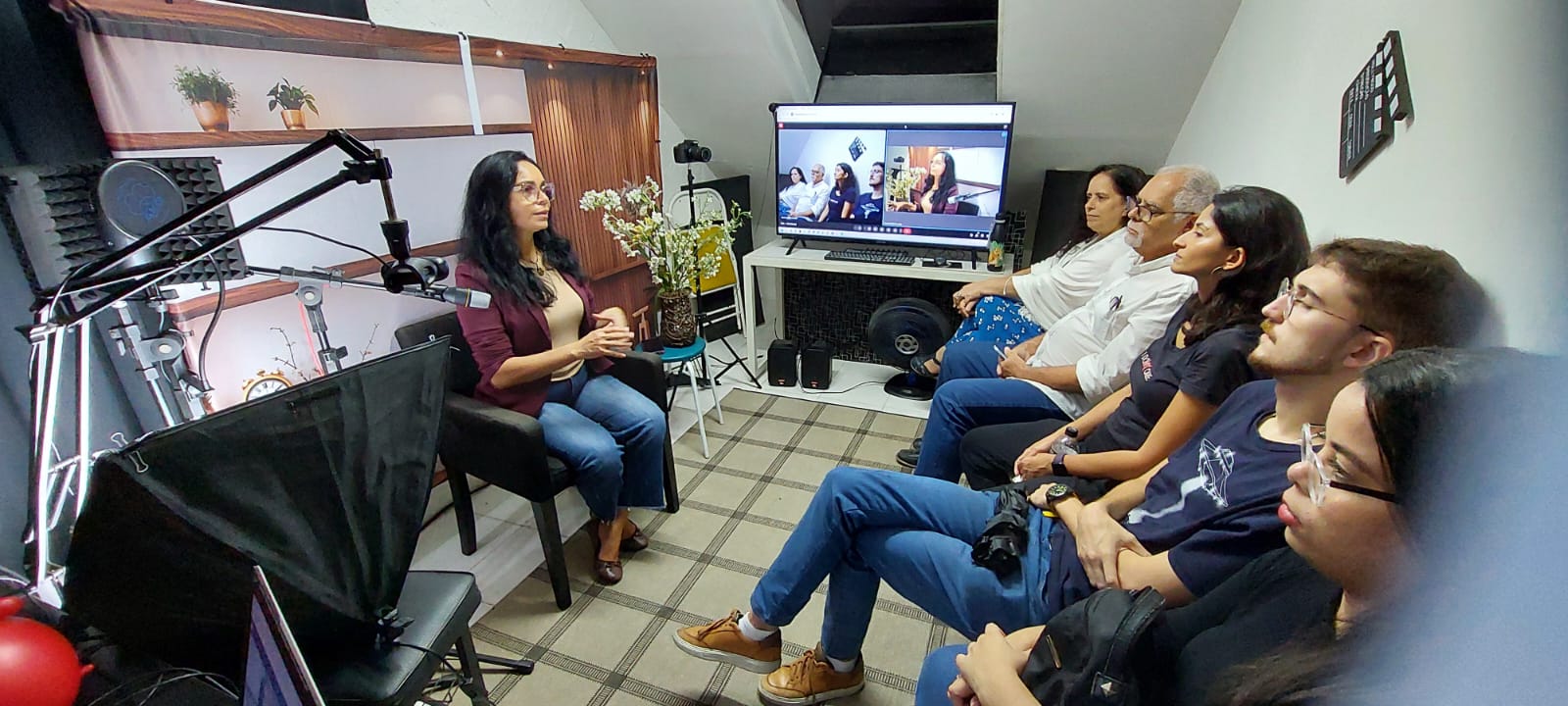 Professora dando aula em estúdio com transmissão online ao vivo